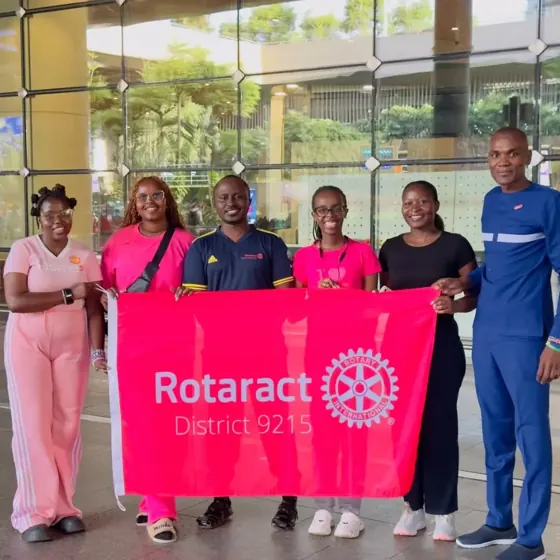 Exchange participants hold a Rotaract District 9215 banner with fellow members