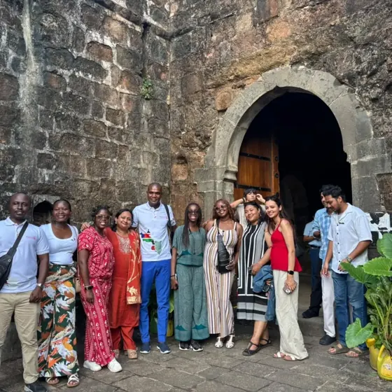 Exchange participants and hosts at a historic stone gateway