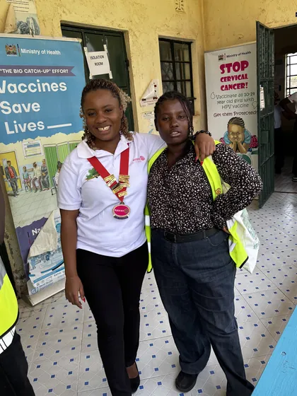 Members beside the clinic's immunisation notice board