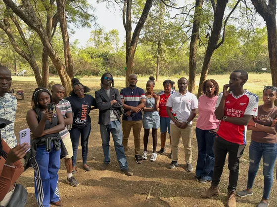 Rotaractors gathered beneath trees at the museum