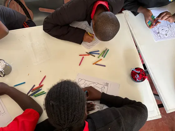A learner works on a drawing during the art day