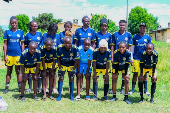 A team in blue and yellow kits gathered beside club members
