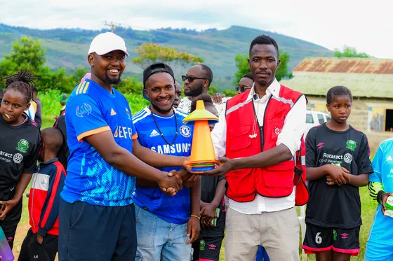 Participants receiving a football during Sports Legacy